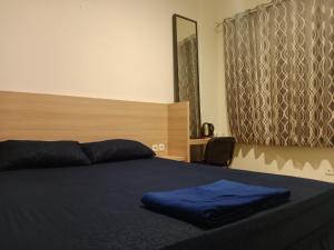 a bedroom with a blue blanket on a bed at Hotel Rimadi in Jakarta +1 photo