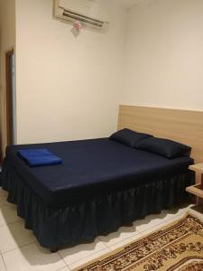 a bedroom with a bed with blue pillows on it at Hotel Rimadi in Jakarta
