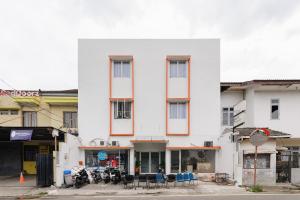 a white building with tables and chairs in front of it at Hotel Rimadi in Jakarta