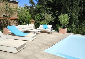 a patio with lounge chairs and a swimming pool at Le Castel Mosan in Namur