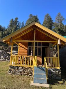 a small cabin with a porch and a staircase at great himalayan hikes homestay shanghar in Shangarh +7 photos