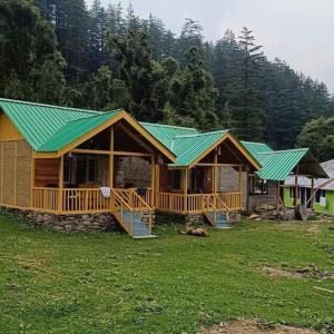 a large wooden house with a green roof at great himalayan hikes homestay shanghar in Shangarh