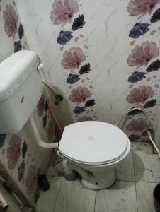 a bathroom with a toilet with flowers on the wall at Chauhans house in Prayagraj