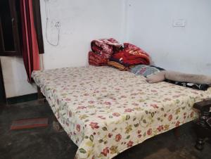 a bed with a comforter on it in a room at Chauhans house in Prayagraj
