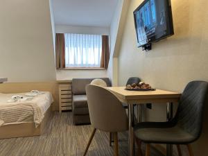 a room with a table and a bed and a television at Sweet Home Konaci in Kopaonik