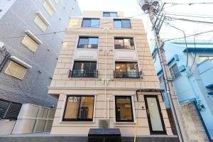 a tall building with many windows on a street at Shinjuku iotele-hatsudai House in Tokyo