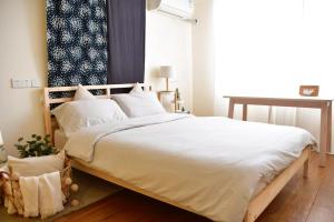 a bedroom with a large bed with white sheets and pillows at Shanghai Hills & Moment Family house close to The Bund in Shanghai
