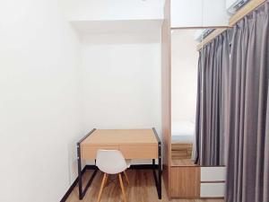 scrivania in camera con sedia bianca di Comfort and Cozy 2BR Cordova Edupartment Semarang Apartment By Travelio a Semarang