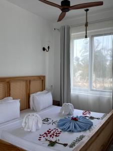 a bedroom with two beds with towels and a window at Mia Boutique Hotel & Restaurant in Michamvi +91 photos