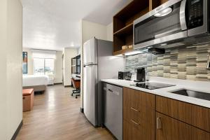a kitchen with a refrigerator and a sink and a microwave at Everhome Suites Nampa Boise in Nampa
