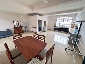a living room with a wooden table and chairs at Come2Us Homestay in Kuala Perlis