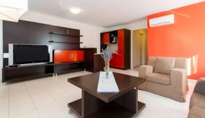 a living room with a tv and a couch and a table at Apartment Residence Marina Portorož LEBIČ 411 in Portorož