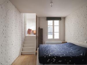 1 dormitorio con 1 cama y pared de ladrillo blanco en Brooklyn Five, en Gante