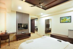 a hotel room with a bed and a television at Sayaji Lodging in Gārgoti