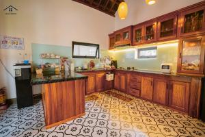 a kitchen with wooden cabinets and a counter top at Da Dia Seala House in Phú Hạnh (5)