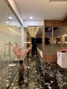 a lobby with a vase of flowers on a marble floor at Sayaji Lodging in Gārgoti