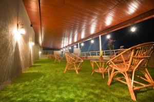 a group of chairs and tables on a patio at night at Sayaji Lodging in Gārgoti