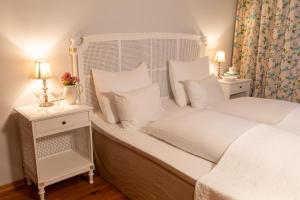 a white bedroom with two beds and two lamps at Tørvis Hotell in Luster