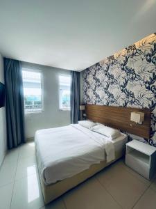a bedroom with a large white bed with a wall at Sovotel @ Kota Damansara 8 in Kota Damansara