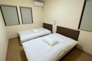 萨摩川内市Nishikata Beach House 1 -西方海岸貸別荘 壱号-的有两张床的房间有两扇窗户