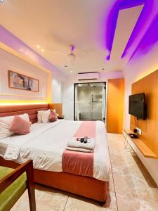 a bedroom with a large bed and a tv at Hotel Cozzy Palace in Surat