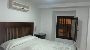 a bedroom with a bed and a window at Pensión Veracruz 2 in Granada