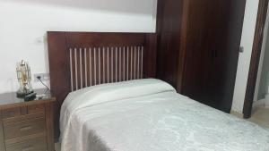 a bedroom with a bed and a wooden headboard at Pensión Veracruz 2 in Granada +7 photos