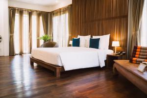 a bedroom with a large white bed with blue pillows at Le Sen Boutique Hotel in Luang Prabang +107 photos