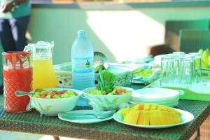 a table with bowls of fruit and bottles of juice at Duggers Motel Lusaze in Kampala +28 photos