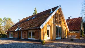 Casa de madera con techo marrón en De Groondbössel, en Enschede