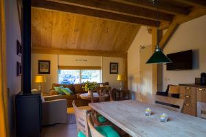 a kitchen and living room with a wooden table at De Groondbössel in Enschede