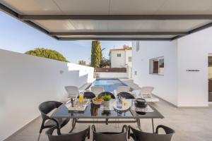 a patio with a table and chairs and a pool at Villa Antonieta in Ayia Napa