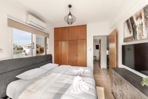 a bedroom with a large white bed and a tv at Villa Antonieta in Ayia Napa +91 photos