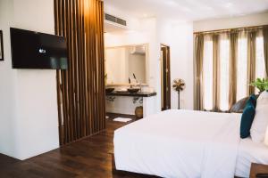 a bedroom with a bed and a desk and a television at Le Sen Boutique Hotel in Luang Prabang