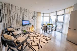 Una sala de estar con una mesa y sillas y un televisor. en Luxurious PENTHOUSE SUITE with Panoramic Views & FREE Parking in Cardiff City Centre, en Cardiff