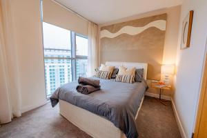 Un dormitorio con una cama y una ventana grande. en Luxurious PENTHOUSE SUITE with Panoramic Views & FREE Parking in Cardiff City Centre, en Cardiff