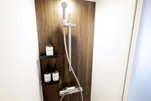 a bathroom with a shower with bottles on a wall at 夢の舎代々木 Yumenoya Yoyogi in Tokyo +47 photos