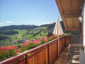 Un balcón con sombrilla y vista a un valle. en Gmosnhof Mölten, en Meltina 7 fotos más