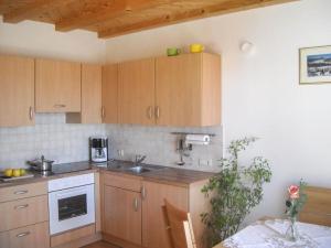 a kitchen with wooden cabinets and a sink and a table at Gmosnhof Mölten in Meltina +8 photos