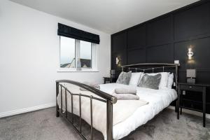 a bedroom with a bed with a black headboard at 3 Bedroom House-Private Parking in Bonnyrigg