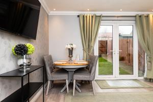 a dining room with a table and chairs and a sliding glass door at 3 Bedroom House-Private Parking in Bonnyrigg