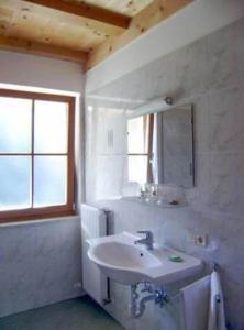 a white bathroom with a sink and a mirror at Gmosnhof Mölten in Meltina
