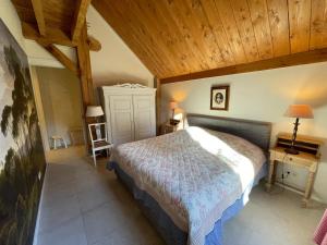 Un dormitorio con una cama y un techo de madera. en De Groondbössel, en Enschede