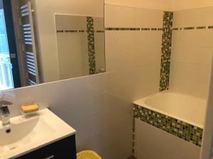 ein Badezimmer mit Waschbecken, Spiegel und Badewanne in der Unterkunft Grande maison familiale, calme, tranquille, 900 m de la plage in Longeville-sur-Mer + 48 Fotos