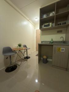 una habitación con un escritorio, una mesa y un lavabo en Condo in Cubao by Cindy, en Manila