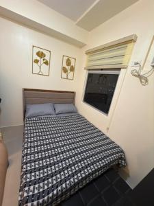 Un dormitorio pequeño con una cama y una ventana. en Condo in Cubao by Cindy, en Manila