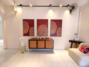 a living room with four paintings on the wall at SunsetChalet 25pax Pool Snooker Bathtub Playground in Kluang