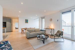 a living room with a couch and a table at L'Académie - Magnifique 3 chambres Krutenau avec parking in Strasbourg