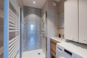 a bathroom with a shower and a washing machine at L'Académie - Magnifique 3 chambres Krutenau avec parking in Strasbourg +7 photos