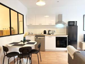 une cuisine avec une table et des chaises dans une pièce dans l'établissement Grand appartement avec terrasse - 4 voyageurs, à Roubaix 4 autres photos